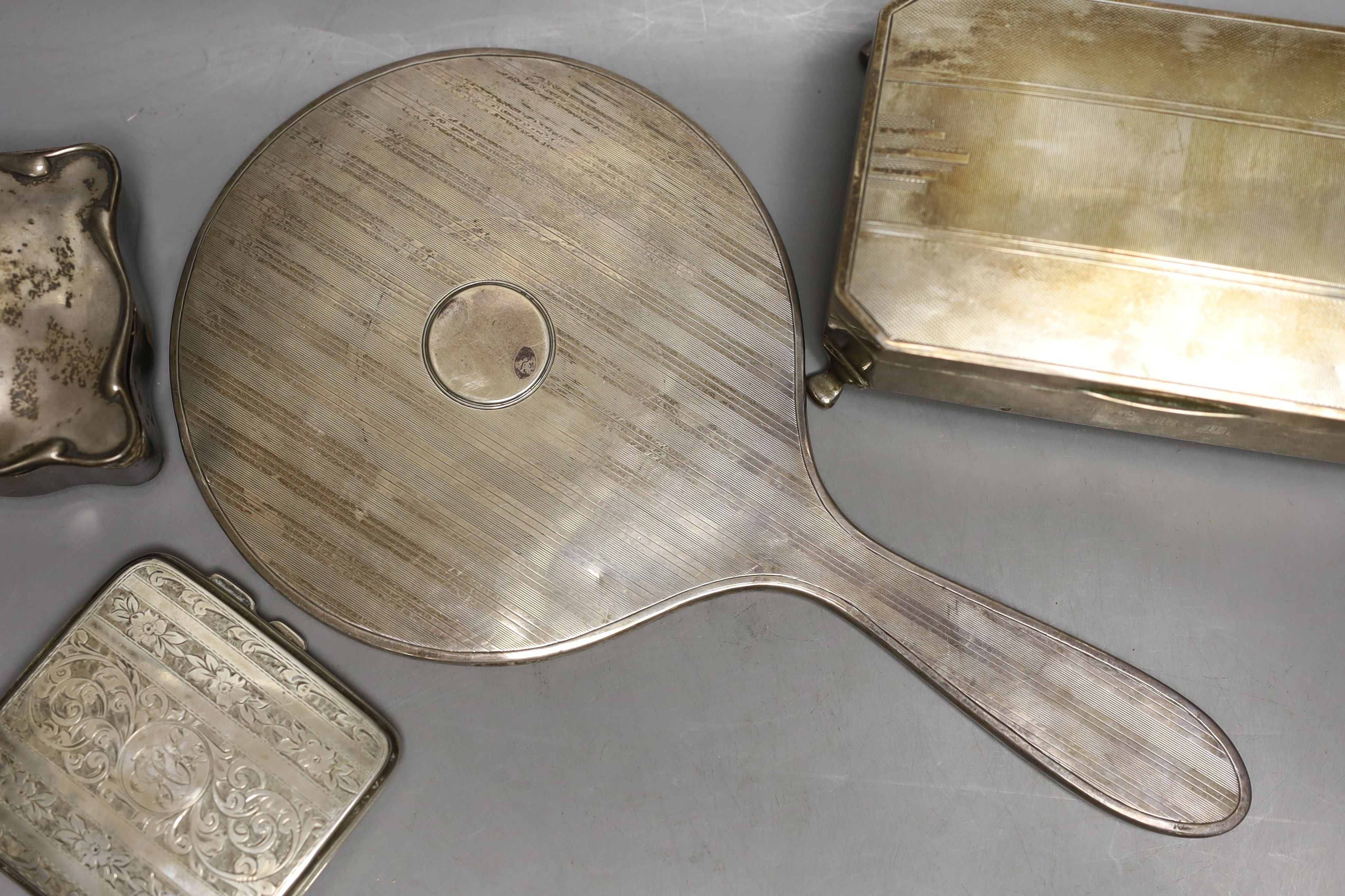 An Art Deco silver mounted cigarette box, a silver cigarette box, silver trinket box and a silver mounted hand mirror.